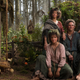 Harfoots pose in a forest in Middle-earth.